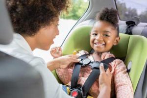 child being put in seat restraint